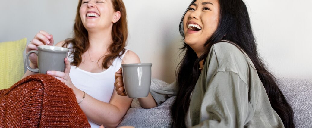 Roommates laughing out loud on the sofa