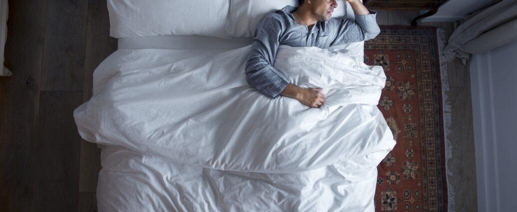 Man on bed with a headache