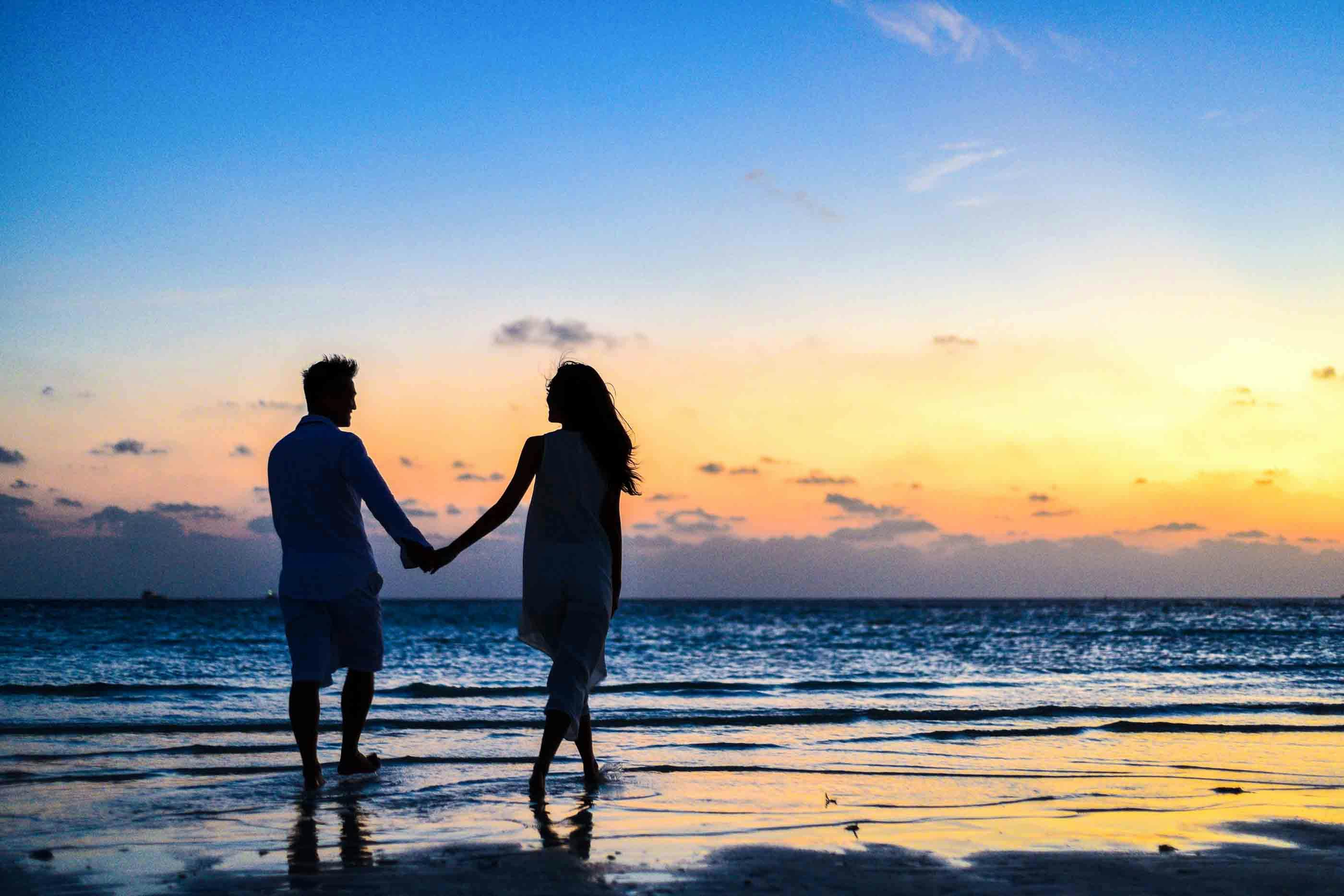 Photo by Asad Photo Maldives: https://www.pexels.com/photo/man-and-woman-holding-hands-walking-on-seashore-during-sunrise-1024960/