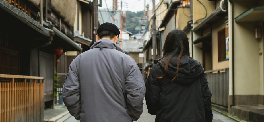 Photo by Ryutaro Tsukata: https://www.pexels.com/photo/couple-walking-on-street-with-concrete-tile-and-old-houses-6249393/