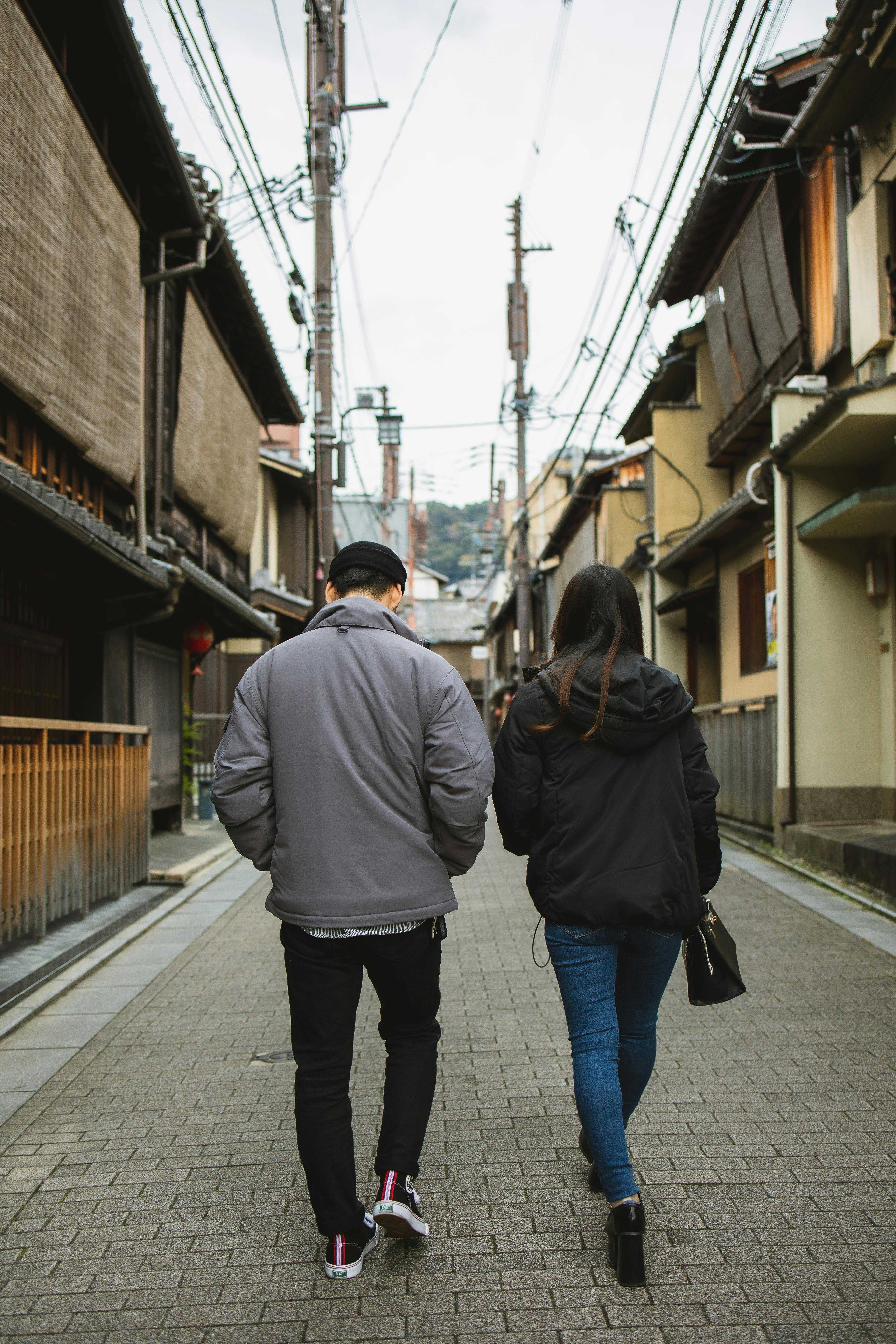 Photo by Ryutaro Tsukata: https://www.pexels.com/photo/couple-walking-on-street-with-concrete-tile-and-old-houses-6249393/